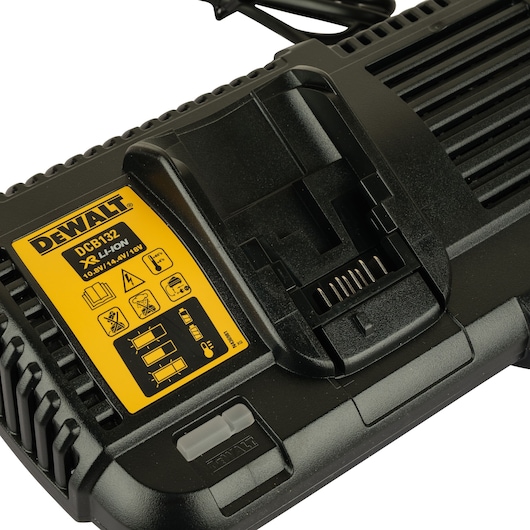 Close-up of a DEWALT DCB132 battery charger with a yellow label showing specifications for charging lithium-ion batteries with 10.8V, 14.4V, and 18V. The charger is black with a visible slot for battery insertion and indicator lights.