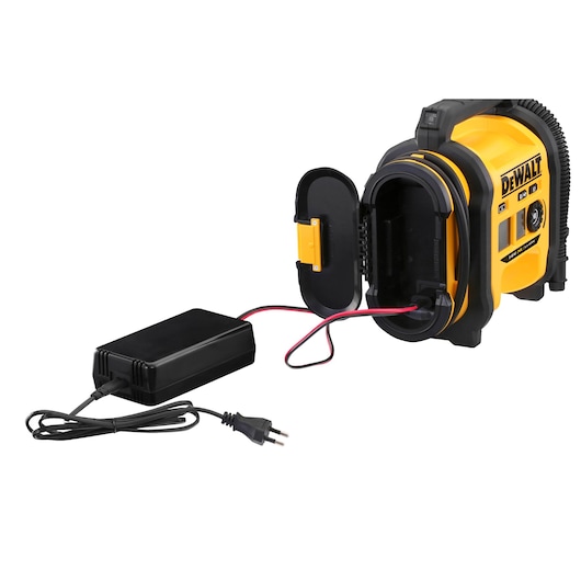 A DEWALT portable air compressor model DCC018N, featuring a yellow and black design, with its front compartment open and connected to a black power adapter with a plug and cable.