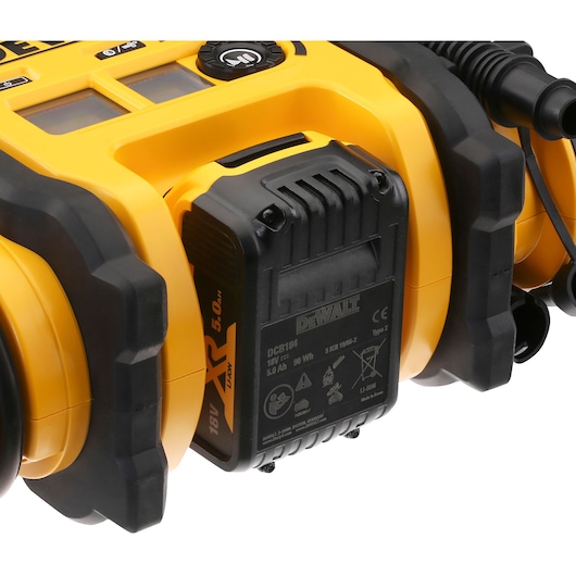 Close-up view of a DEWALT DCC018N portable inflator with an attached 18V XR Li-Ion 5.0Ah battery pack, showing the device's yellow and black design and battery details.
