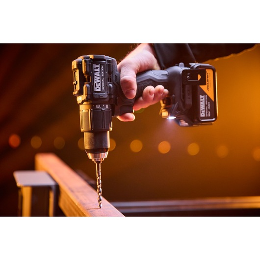 DEWALT x McLaren F1 Team 18V XR Special Edition Hammer Drill Driver with 4Ah battery drilling a metal bar