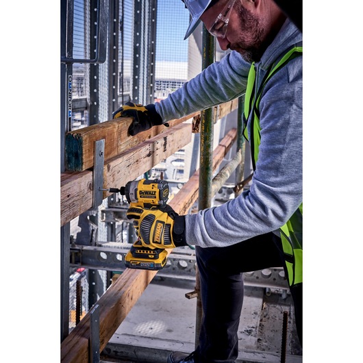 DEWALT DCF860N-XJ, DCF860N impact driver used for woodworking at a construction site. Photography category.