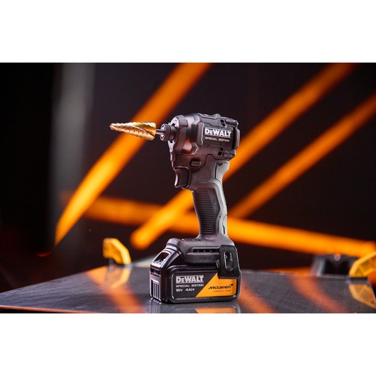 DEWALT x McLaren F1 Team 18V XR Special Edition Impact Driver with 4Ah battery standing on a metal sheet