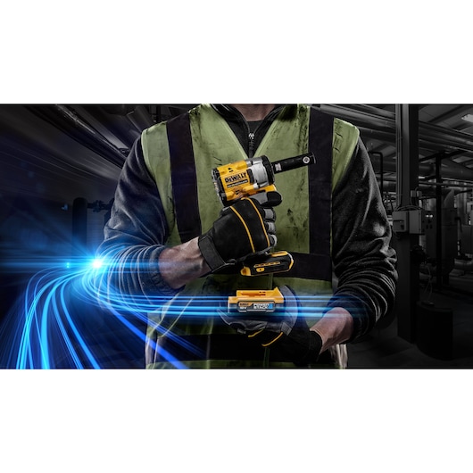 A person wearing a green safety vest and black gloves is holding a DEWALT cordless impact wrench. Blue energy lines are illustrated across the foreground, suggesting power and technology. The background shows an industrial environment with machinery.