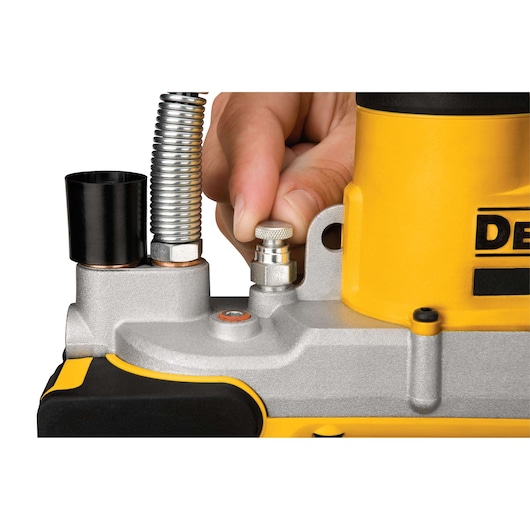Close-up of a person adjusting a metallic component on a DEWALT power tool with yellow housing.