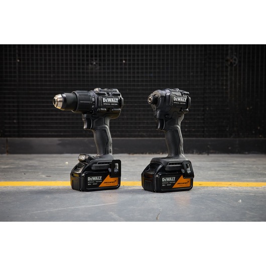 DEWALT x McLaren F1 Team 18V XR Special Edition Hammer Drill Driver and Compact Impact Driver with 4Ah batteries standing on a concrete floor