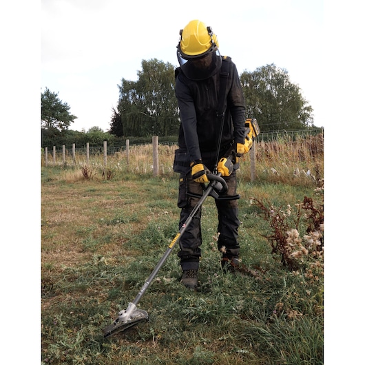 DEWALT brush cutter used outdoors. SKUs: DCMASED57X1, DCMASED9N, DCMASPH6N, DCMASPS5N, DCMASST1N, DCMASBC1N, DCMAS5713X1
