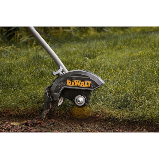 A DEWALT lawn edger in use, trimming the edge of a grassy lawn.