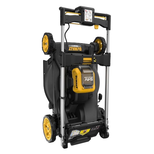 A DEWALT 54V cordless lawn mower shown in a vertical, folded storage position. The mower has large yellow and black wheels, a battery compartment on the top, and a sturdy handle with an instruction label. The product is designed for easy storage and efficient use.