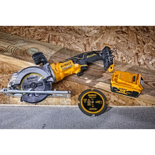 DEWALT cordless circular saw with blade, battery, and extra disc on wood surface.
