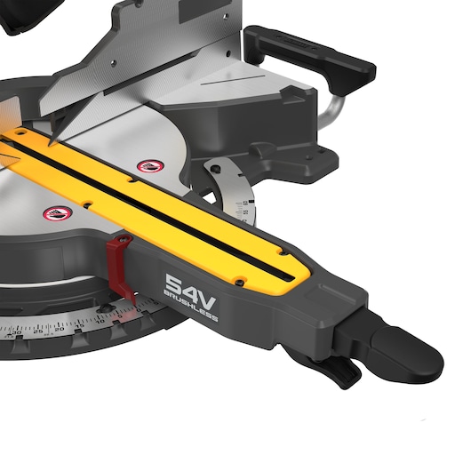 Close-up view of a DEWALT 54V brushless miter saw, showing the cutting blade, yellow rail, and measurement scale with a handle and safety warning labels.