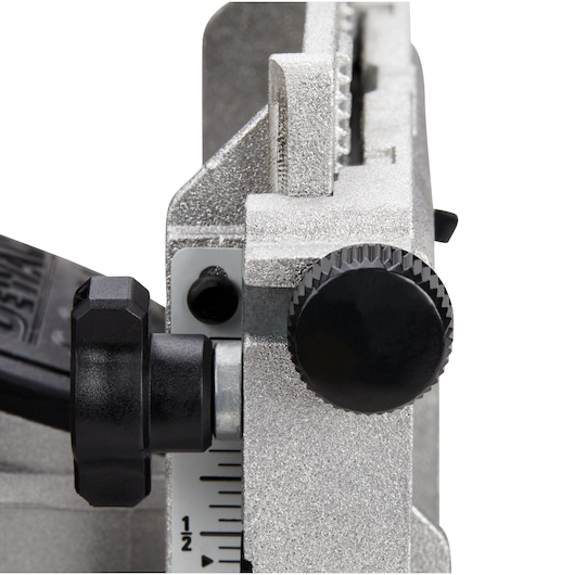 Close-up of a DEWALT DCW682N tool adjustment knob and scale, showing part of a metallic silver body with black adjustment dials and measurement markings.