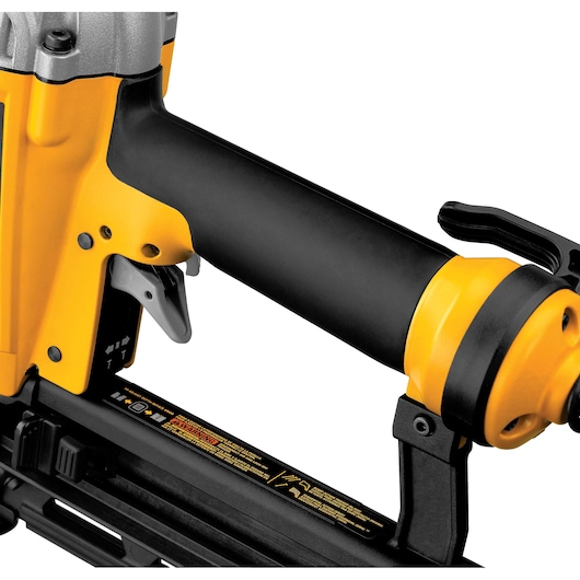 Close-up of a DEWALT DPN1664 nail gun showing trigger, handle, and safety warnings on black and yellow body.