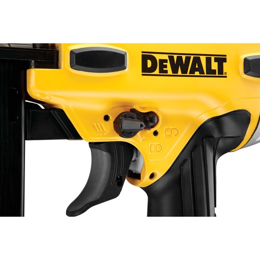 Close-up view of a DEWALT branded power tool, showing the yellow and black handle, trigger, safety switch, and part of the control panel.