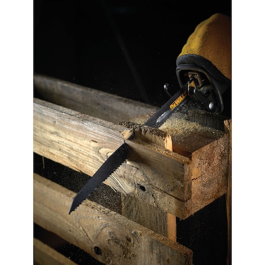 DEWALT saw blade cuts through wooden pallet, creating sawdust during woodworking.