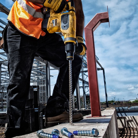 DEWALT DT60814, DT60814-QZ drill bit used on a construction site by worker in safety gear.