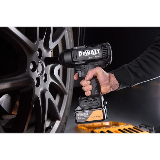 DEWALT x McLaren F1 Team 18V XR Special Edition Impact Wrench with 5Ah battery tightening a wheel nut