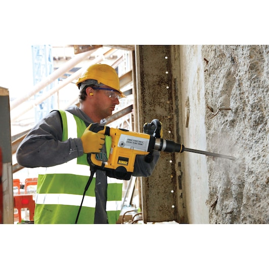 DEWALT DT8087, DT8087-QZ hammer drill used on concrete wall at construction site. Product category: Photography.