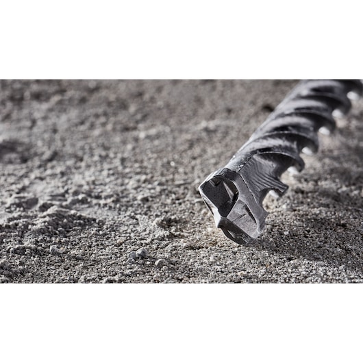 Close-up of a DEWALT concrete drill bit DT8965 lying on rough concrete surface.