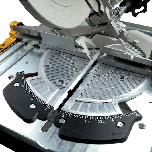 Close-up view of a DEWALT DW743N mitre saw showing the angle adjustment scale and metallic work surface for precise cutting.