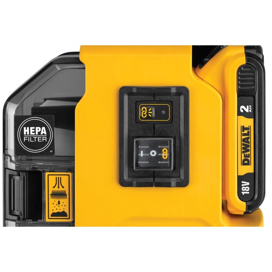 Close-up of a DEWALT power tool featuring a HEPA filter, control buttons, and an 18V 2Ah battery indicator. The tool has a yellow and black design.