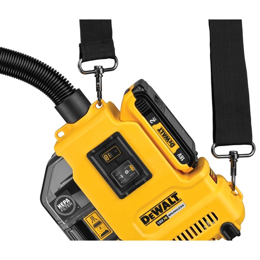 Close-up view of a DEWALT cordless tool featuring a HEPA filter, an 18V battery, control interface, and adjustable carrying straps.
