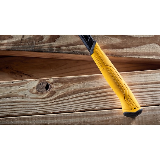 Close-up of a DEWALT yellow and black hammer handle resting on wooden planks.