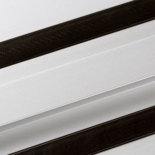 Close-up image of a DEWALT guide rail, showing two parallel black strips on a white or metallic surface. The product is used for precise guiding of power tools such as saws.