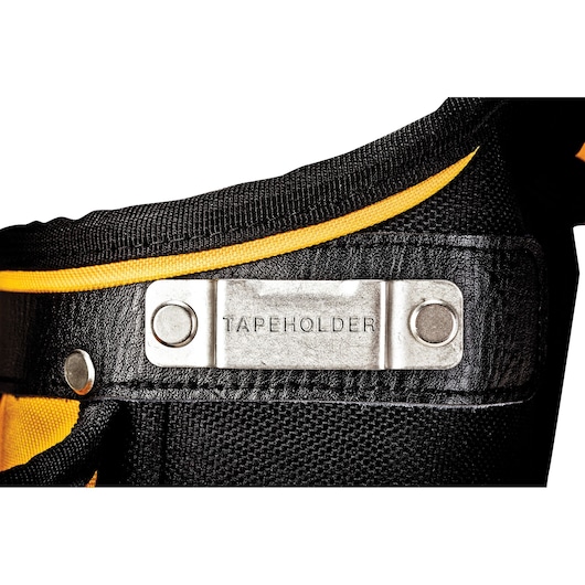 Close-up of a tape holder attachment on a black and yellow tool belt, showing a metal plate labeled 'TAPEHOLDER'.