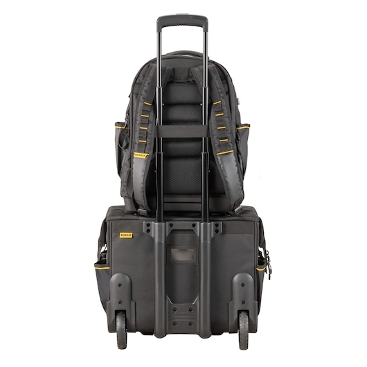 A black DEWALT backpack stacked on top of a matching wheeled trolley case, viewed from the back. The trolley handle is extended and both pieces feature yellow details.