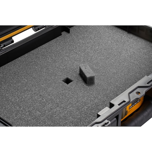 Close-up of a DEWALT tool case with a foam insert designed to protect equipment, showing a removable foam piece and cutout for customizable storage.
