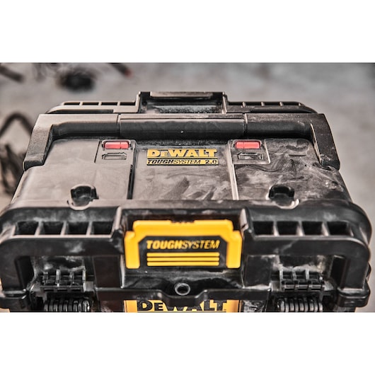 Close-up view of a DEWALT ToughSystem 2.0 storage box, showing its rugged black and yellow design and secure locking mechanism.