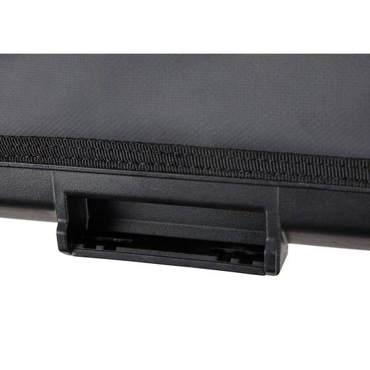 Close-up view of a black plastic latch or connector on a hard case, with a textured surface and fabric reinforcement.