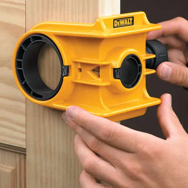 Photo of DEWALT D180004 yellow door lock installation kit in use on wood, close-up view.